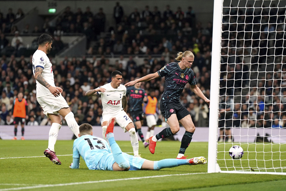 Manchester City's Erling Haaland, right, scores his side's first goal during the match against Tottenham Hotspur at Tottenham Hotspur Stadium in London, England on Tuesday. [AP/YONHAP]