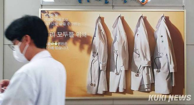 3월13일 서울의 한 종합병원 로비에 걸린 대형사진 옆으로 의료진이 지나가고 있다. 사진=곽경근 대기자