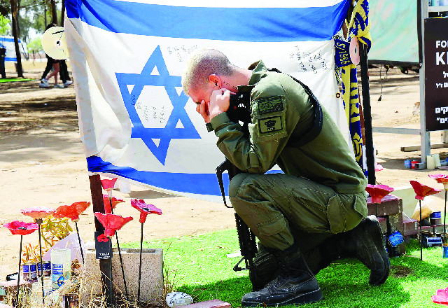 한 군인이 13일(현지시간) 이스라엘 남부 레임 키부츠 인근 축제장에서 지난해 하마스의 기습 공격으로 사망한 희생자들을 추모하고 있다. AFP연합뉴스