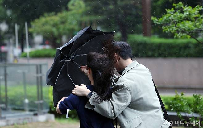 (전국에 강풍을 동반한 비가 내린 지난 11일 서울 종로구 도심을 지나는 한 시민들이 강한 바람에 위태로운 모양의 우산에 의지한 채 발걸음을 재촉하고 있다./사진=뉴스1