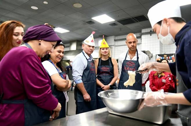 주한 대사관 관계자들이 치킨대학의 '글로벌 치킨캠프'에서 BBQ 황금올리브 치킨 조리 과정을 배우는 모습. /사진=제너시스BBQ