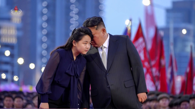 김정은 북한 국무위원장이 14일 평양 북쪽의 신도시 ‘전위거리’ 준공식에서 딸 주애에게 귓속말하고 있다. 주애가 공개석상에 등장한 것은 지난 3월 15일 이후 두 달만이다. 조선중앙TV 캡처