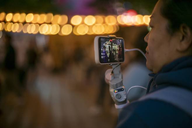 5월2일 저녁 김은희씨(가명)가 서울광장에서 열린 ‘이태원 참사 특별법 국회 통과 추모 문화제’를 유튜브로 생중계하고 있다. ⓒ시사IN 신선영