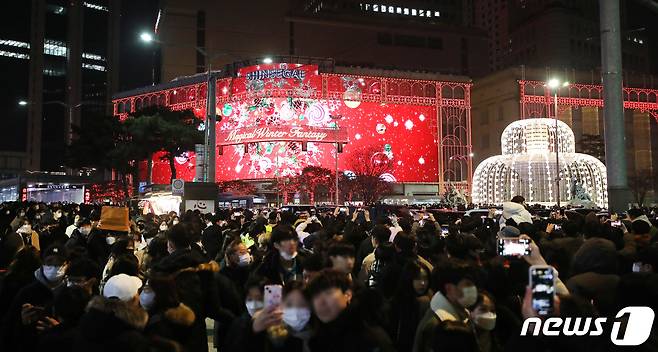 크리스마스인 25일 저녁 서울 중구 명동에서 시민들이 신세계백화점 외벽의 미디어 파사드를 관람하고 있다. 2022.12.25/뉴스1 ⓒ News1 임세영 기자