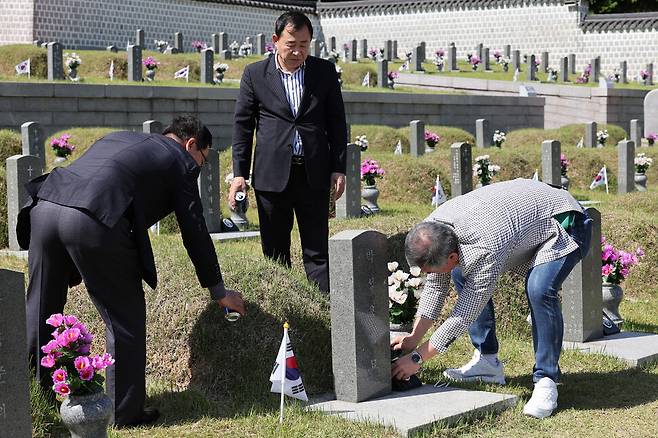 고 박성용 열사의 고등학교 동창 김보근(63·왼쪽부터)씨, 최운태(62)씨, 이의철(62)씨가 박 열사의 묘소에 맥주를 뿌리고 묘비를 닦고 있다. 김영원 기자