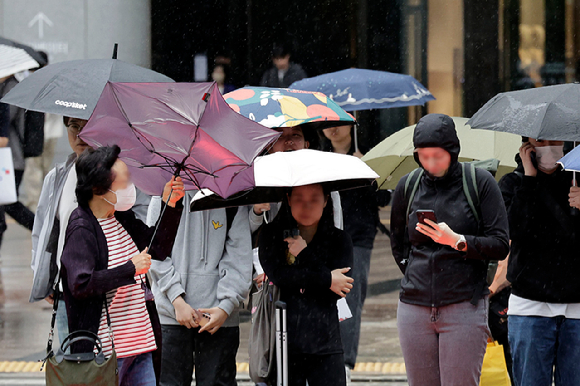비가 내리고 있는 지난 15일 오후 서울 용산역 인근에서 한 시민의 우산이 강한 바람에 뒤집히고 있다. [사진=뉴시스]