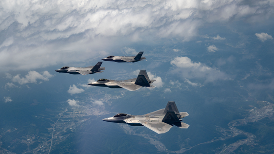 South Korean F-35A and U.S. F-22 fighters take part in a joint combat drill in an apparent show of force against North Korean military threats in a photo provide by the U.S. Air Force Thursday. The exercise took place over a central region in South Korea, conducting attack and defense missions. It marked the first exercise of its kind between the two sides’ advanced aircraft. [YONHAP]