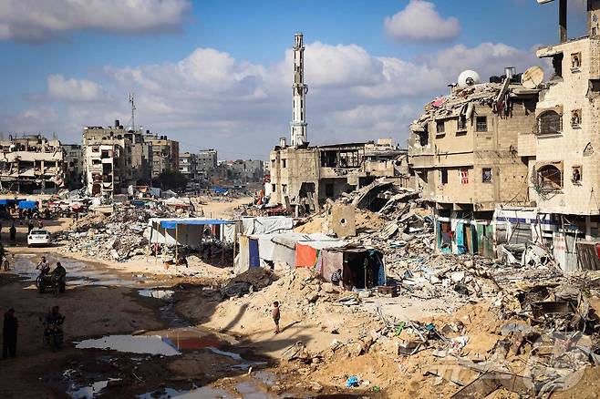 16일(현지시간) 이스라엘군 공격으로 폐허가 된 가자지구 남쪽 도시 칸 유니스의 건물 잔해사이로 팔레스타인 피난민들의 널빤지 판잣집들이 들어서 있다. 2024.05.16 ⓒ AFP=뉴스1 ⓒ News1 김성식기자