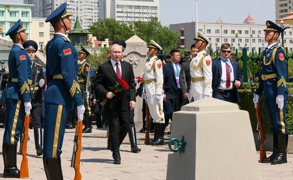 중국을 국빈방문한 블라디미르 푸틴 러시아 대통령이 17일 헤이룽장성 하얼빈에서 2차 세계대전 말 일본군과의 전투에 참전했던 소련군 전사자를 추모하는 기념비에 헌화하고 있다. 타스 연합뉴스
