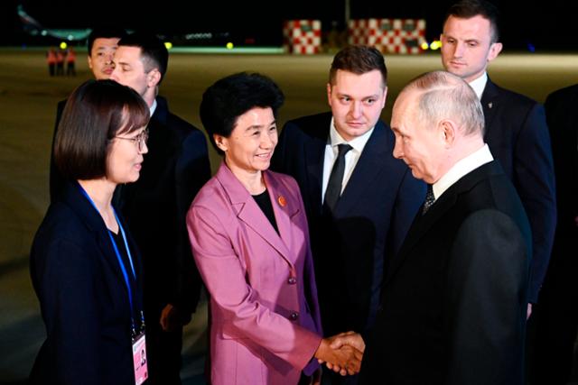 중국을 국빈 방문 중인 블라디미르 푸틴(아랫줄 오른쪽) 러시아 대통령이 17일 중국 하얼빈 공항에 도착해 관계자들의 환영을 받고 있다. 하얼빈=AP 연합뉴스