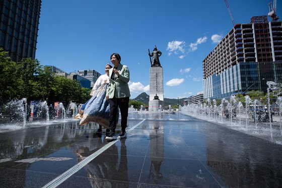 맑고 화창한 날씨를 보인 16일 서울 광화문광장을 찾은 관광객들이 푸른 하늘을 배경으로 기념 촬영을 하고 있다. 뉴스1