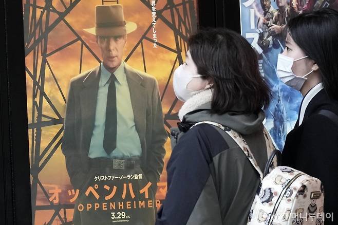[도쿄=AP/뉴시스] 29일 일본 도쿄에서 시민들이 영화 '오펜하이머' 홍보 포스터 옆을 지나고 있다. '원자폭탄의 아버지' 오펜하이머의 생애를 다룬 영화 '오펜하이머'가 피폭국인 일본에서 29일 개봉했다. '오펜하이머'는 제96회 아카데미 시상식에서 작품상 등 7관왕에 올랐다. 2024.03.29. /사진=민경찬