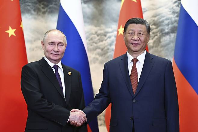 블라디미르 푸틴(왼쪽) 러시아 대통령이 지난 16일 중국 베이징에서 시진핑 중국 국가주석과 정상 회담에 앞서 악수하며 기념 촬영을 하고 있다. /AP=뉴시스
