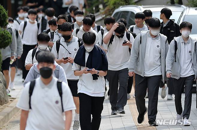 [서울=뉴시스] 백동현 기자 = 지난 2022년 5월 25일 오후 서울 시내 한 중학교 앞에서 학생들이 스마트폰을 보면서 하교하고 있다. 2022.05.25. livertrent@newsis.com