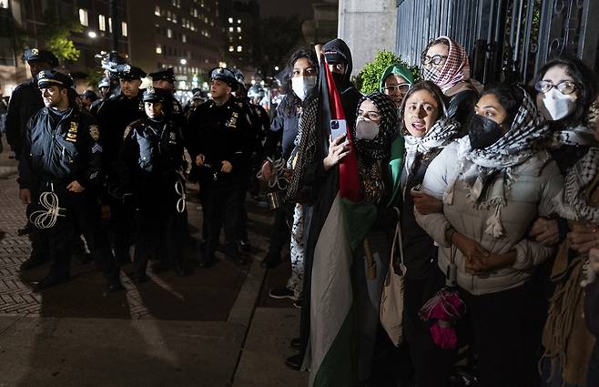 4월30일 미국 뉴욕 컬럼비아 대학에서 열린 반전 시위에 참여한 학생들이 경찰에 대응해 노래를 부르며 구호를 외치고 있다.ⓒAP Photo