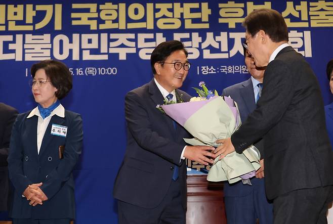 더불어민주당 국회의장 후보로 선출된 우원식 의원이 16일 오전 국회 의원회관에서 열린 제22대 전반기 국회의장단 후보 선출을 위한 당선자 총회에서 이재명 대표로부터 꽃다발을 받고 있다. ⓒ연합뉴스