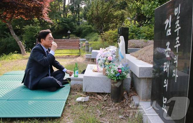 국회의장 후보로 선출된 우원식 더불어민주당 의원이 17일 오후 경기 남양주 모란공원에 있는 김근태 전 의원 묘를 찾아 참배한 뒤 혼자 소주잔을 기울이고 있다. (SNS 갈무리) ⓒ 뉴스1