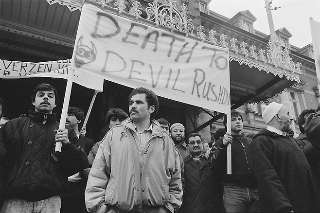1989년 3월 유럽 내 무슬림들이 루슈디를 “악마 루슈디”로 지칭하며 규탄하는 집회의 모습. [Rob Croes·Anefo·Wikimedia Commons]