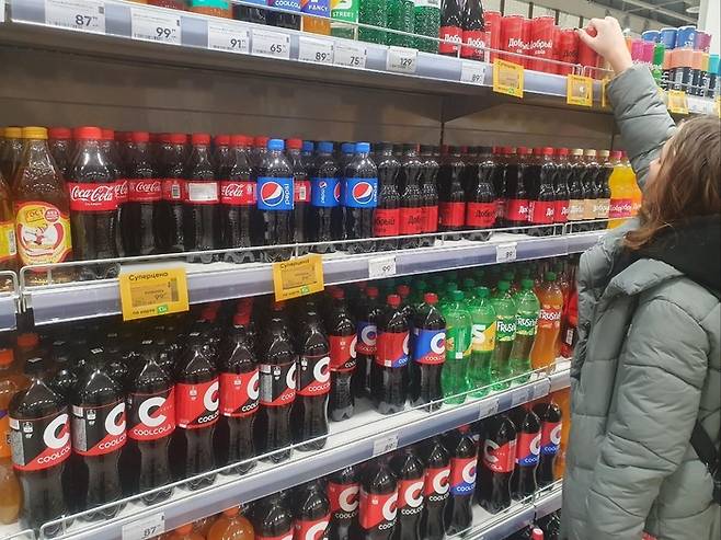 러시아 모스크바의 한 대형 마켓에서 한 러시아 소녀가 콜라를 구매하고 있다. 병행 수입된 코카콜라와 펩시콜라도 판매되고 있지만 소녀는 러시아산 도브리콜라를 선택했다. [사진 제공=연합뉴스]