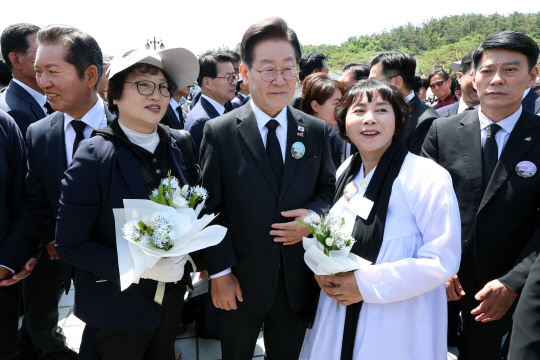 제44주년 5·18 광주민주화운동 기념식이 열린 18일 광주 북구 국립 5·18 민주묘지에서 이재명 더불어민주당 대표가 유족을 만나 기념촬영을 하고 있다. 연합뉴스