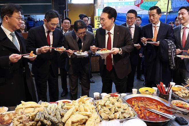 지난해 12월6일 윤석열 대통령이 부산 중구 깡통시장에서 이재용 삼성전자 회장 등 대기업 총수들과 떡볶이를 시식하고 있다.ⓒ연합뉴스