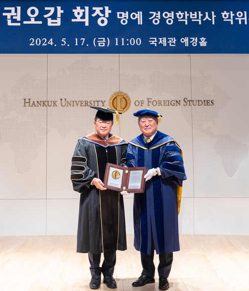 지난 17일 한국외대 국제관에서 권오갑 HD현대 회장(왼쪽)이 명예 경영학 박사 학위를 받고 있다.  HD현대