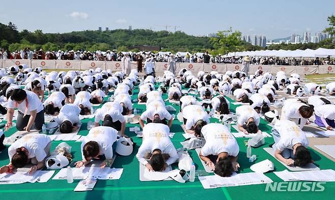 [양주=뉴시스] 전신 기자 = 19일 경기도 양주 회암사지 특설무대에서 열린 '회암사 사리 이운 기념 문화축제 및 삼대화상 다례재'에서 참석자들이 108배를 하고 있다. (대통령실통신사진기자단) 2024.05.19. photo1006@newsis.com