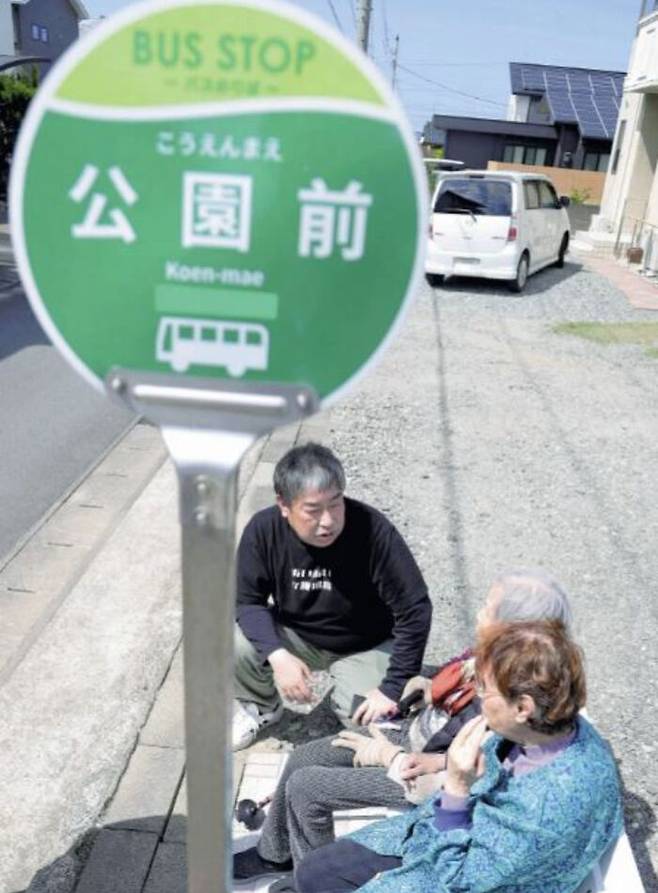 일본 '가짜 버스 정류장'을 방문한 치매 노인과 이야기 중인 나카무리씨. (사진=요미우리신문 홈페이지 캡처)