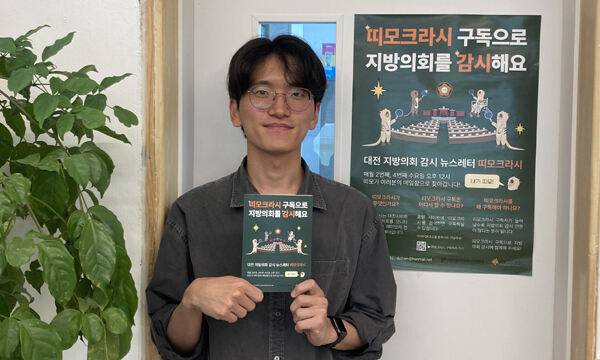 설재균 ‘띠모크라시’ 발행인이 지난 9일 인터뷰 후 띠모크라시 팸플릿을 들고 사진을 찍고 있다.&nbsp;강은선 기자&nbsp;