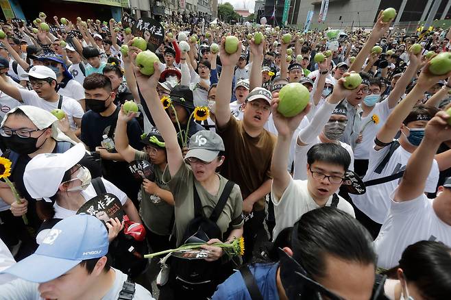 제1야당인 국민당(TPP) 지지자들이 19일 대만 타이베이에서 라이칭더 신임 총통의 취임식을 하루 앞두고 여당인 민진당에 반대하는 시위를 벌이는 과정에서 부정 투표용지를 상징하는 대형 구아바를 들고 있다./AP 연합뉴스