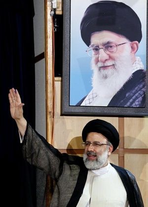 지난 2017년 4월 14일 이란 수도 테헤란의 내무부 청사에서 당시 대선에 출마한 에브라힘 라이시 후보가 아야톨라 세예드 알리 하메네이 이란 최고지도의 사진 아래를 지나며 지지자들을 향해 손을 흔들고 있다. ⓒ AFP/연합뉴스