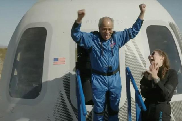 전직 미국 공군 파일럿이자 1960년대 첫 흑인 우주비행사 후보였던 에드 드와이트(왼쪽)가 19일 텍사스주 밴 혼 발사장 인근에 착륙한 우주선 캡슐에서 걸어 나오며 두 팔을 번쩍 들고 있다. 90세인 그는 최고령 우주비행 기록을 세웠다. AFP 연합뉴스(블루오리진 웹캠 라이브 방송 화면 캡처)