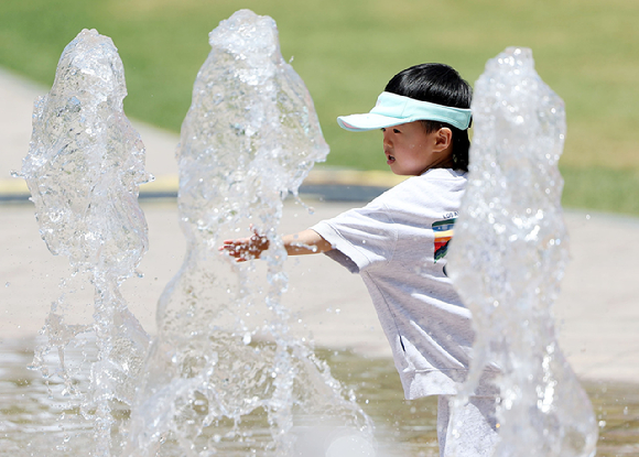 19일 서울 중구 서울광장 내 분수대에서 한 어린이가 물놀이를 즐기고 있다. [사진=뉴시스]