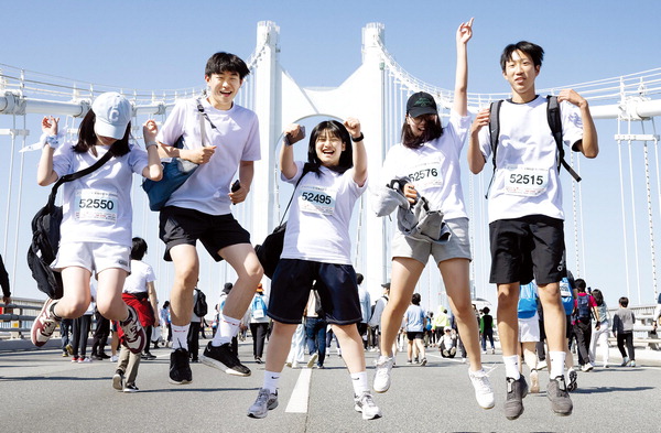 인생샷 위한 ‘점프’- 19일 ‘성우하이텍과 함께하는 2024 다이아몬드브리지 국제걷기축제’ 참가자들이 광안대교 상판 위에서 힘차게 뛰어 오르며 열의를 다지고 있다.