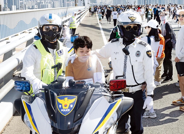 경찰아저씨와 찰칵- 어린이 참가자가 광안대교에 투입된 경찰 오토바이를 타고 경찰들과 함께 인증샷을 찍고 있다.