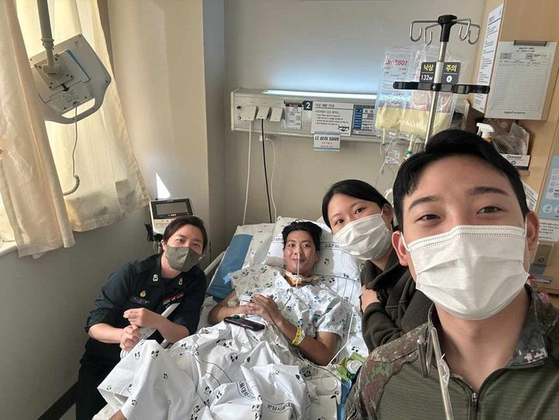 Choi, on the bed, takes a picture with his army colleagues in a hospital. The picture is uploaded on a Facebook page relaying stories about military experiences on Thursday, along with Choi's father's thank you letter. [SCREEN CAPTURE]