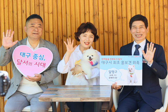 Dalseo District's dog ambassador, ″Dalmunggoo,″ poses for a photo with its owners, left, and Lee Tae-hoon, head of Dalseo District office, far right, after he was appointed as the district's dog ambassador. [DALSEO DISTRICT OFFICE]
