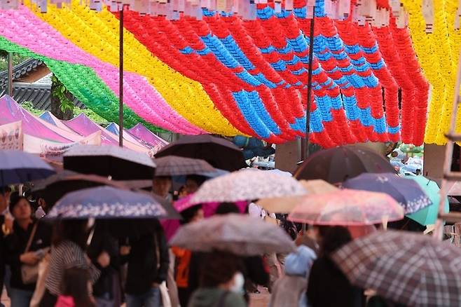 부처님 오신 날인 지난 15일 오후 서울 강남구 봉은사에 비가 내리자 시민들이 우산을 쓰고 비를 피하고 있다. 연합뉴스