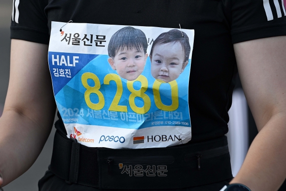 하프 코스 참가자 김효진씨가 배번표에 자녀 사진을 붙이고 출발 준비를 하고 있다. 오장환 기자
