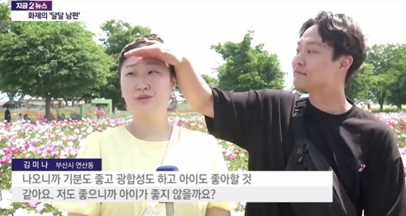 한상오(오른쪽)씨가 아내 김미나씨를 위해 손으로 햇빛을 가려주는 모습. YTN 캡처