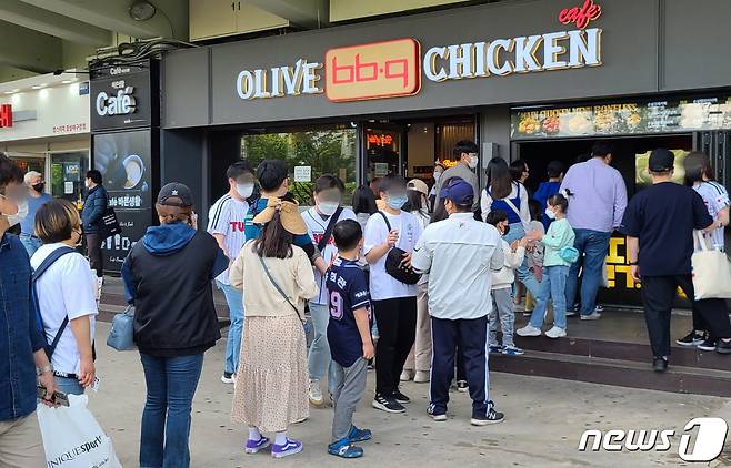 지난달 30일 서울 잠실야구장을 찾은 가족 단위 야구팬들이 치킨 구입을 위해 BBQ 잠실야구장점 앞에 줄 서 있다. (제너시스 BBQ 제공) 2022.5.1/뉴스1