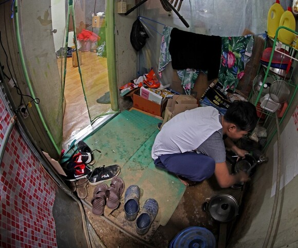지난 1월16일 저녁 경기도 포천의 한 시설채소 농장에서 캄보디아 출신 이주노동자가 비닐하우스 기숙사에서 찬물로 그릇을 씻고 있다. 이정용 선임기자 lee312@hani.co.kr
