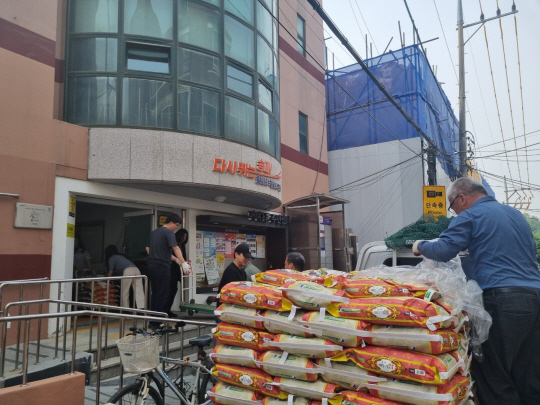 사람들이 서울 송파구 관내 독지가가 보내온 쌀을 차에서 내리고 있다. 송파구청 제공