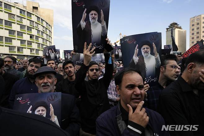 [테헤란=AP/뉴시스] 에브라힘 라이시 이란 대통령이 헬리콥터 추락사고로 숨진 가운데 오는 6월28일(현지시각) 보궐선거가 치러지는 것으로 알려졌다. 사진은 20일 이란 수도 테헤란의 광장에서 시민들이 라이시 대통령의 사진을 들고 그를 추모하는 모습. 2024.05.21