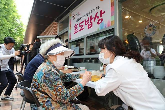 21일 점심식사를 하기 위해 마포구 효도밥상 경로당을 찾은 어르신들이 보건소 직원의 안내를 받으며 혈압과 혈당을 체크하고 있다. 마포구 제공.
