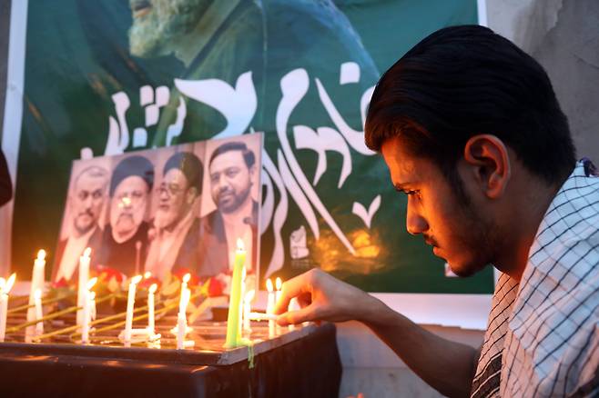 20일 이라크 바그다드의 이란 대사관 앞에서 한 남성이 촛불을 밝히며 전날 헬기 추락 사고로 숨진 이란 각료들을 추모하고 있다. /연합뉴스