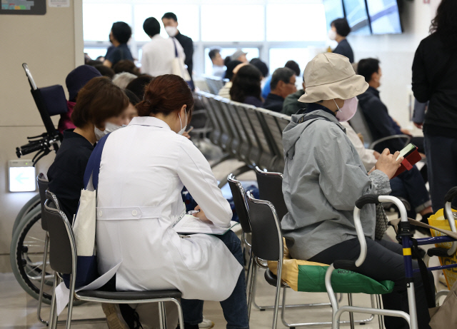 의정 갈등이 계속되는 가운데 22일 서울의 한 대학병원 진료실 앞에서 한 의사가 대기 중인 환자에게 다가가 진료를 보고 있다. <연합뉴스>