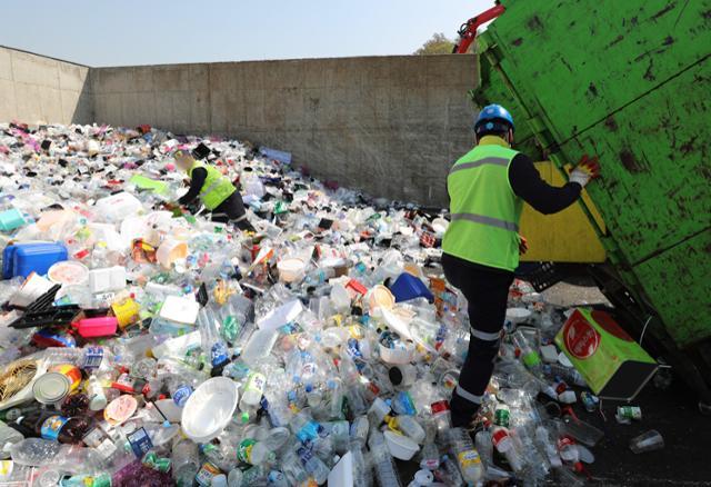 한 쓰레기 처리장에서 작업자가 산더미처럼 쌓인 플라스틱 쓰레기를 처리하고 있습니다. 한국일보 자료사진