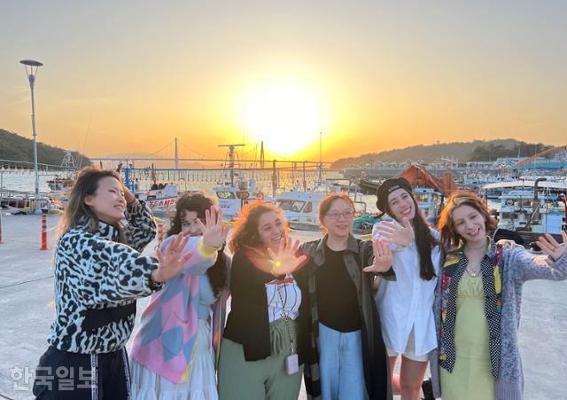 고흥으로 '촌캉스'를 온 서울 거주 외국인들이 녹동항 일몰을 배경으로 기념사진을 찍고 있다.