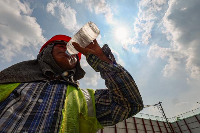 서울 한낮 기온이 35도까지 치솟으며 무더운 날씨를 보인 지난해 8월 1일 오후 서울 시내 한 공사현장에서 한 건설노동자가 물을 마시고 있다. 연합뉴스